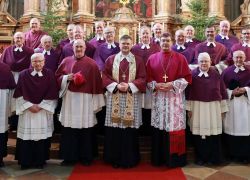 Eine Gruppe von Geistlichen steht in festlicher Kleidung für ein Foto im Stift Reichersberg während der Propstwahl.