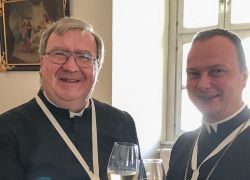 Zwei Geistliche stoßen im Stift Reichersberg mit Sektgläsern an, um das 25-jährige Priesterjubiläum von H. Thomas zu feiern.