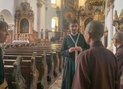 Eine Gruppe von Menschen nimmt an einer Stiftsführung im prächtigen Inneren des Stift Reichersberg teil.