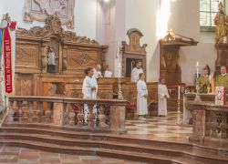 Priester zelebrieren ein Pontifikalamt im Stift Reichersberg, umgeben von Ministranten und Standartenträgern.