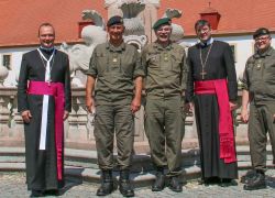 Militärkommandant und Geistliche posieren vor dem Brunnen beim Besuch im Stift Reichersberg.