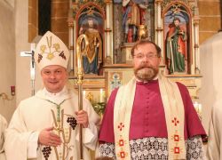 Vier Geistliche feiern im Stift Reichersberg ein Professjubiläum vor einem kunstvollen Altar.