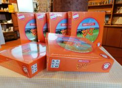 Mehrere orangefarbene Spielekartons "Innviertel DKT" sind auf einem Tisch in einem gemütlichen Laden bei Stift Reichersberg ausgestellt.