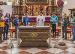 Eine Gruppe von Menschen versammelt sich zum Gebet im Stift Reichersberg auf dem Jakobsweg.